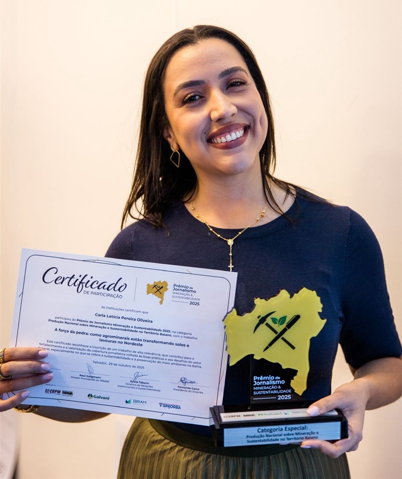 Carla Letícia sorrindo, com o certificado e o troféu do Prêmio de Jornalismo Mineração e Sustentabilidade 2025